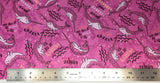 Flat swatch unique narwhal printed fabric in pink (magenta fabric with tossed pink cartoon narwhals and "Unicorn of the sea" "You are strange and wonderful" text, tossed white sea plants behind and pink/white stars)