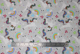 Flat swatch unicorn and rainbows fabric (light grey fabric with tossed white unicorns with rainbow coloured mains and tails, tossed rainbows with clouds, tossed hearts and butterflies in white and rainbow colours)