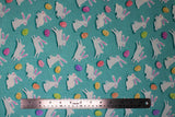 Flat swatch Busy Bunny fabric (teal blue fabric with white polka dots and tossed white bunnies and colourful easter eggs)