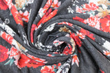 Swirled swatch black/red roses jersey knit fabric (charcoal fabric with white flower silhouettes and red colourway flower clusters)