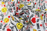 Swirled swatch White fabric (white fabric with busy tossed design of black "Thank you" text in various styles/fonts, tossed yellow smiley faces some with red heart eyes, and tossed hearts and heart outlines in red)