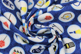 Swirled swatch Gadgets fabric (blue textured look fabric with large white circular badges allover outlined in light blue with police related emblems within/cartoon style: vests, cuffs, stop signs, etc.)