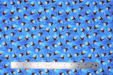 Flat swatch firefly printed fabric in fireflies (light/medium blue marbled fabric with blue shadow cattail plants and black/white lit fireflies with glowing yellow/orange lights)