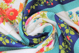 Swirled swatch flower bucket stripe fabric (thick white stripes with evenly spaced floral arrangements in buckets in pink, red, orange, and blue flowers with greenery. Alternating is a medium width navy stripe with green floral and red and blue berries. These two stripes are repeated through out and each stripe is separated with a thin aqua stripe with tiny white polka dots)