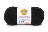 A ball of Lion Brand Touch of Alpaca yarn in black shade on white background
