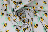 Swirled swatch grey bee fabric (pale grey fabric with cartoon yellow and black bees with pale teal wings tossed allover)