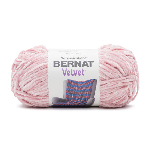 A ball of Bernat Velvet yarn in pale pink shade on white background