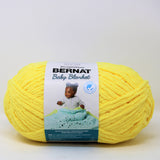 A ball of Bernat Baby Blanket yarn in shade Buttercup (bright vibrant yellow)