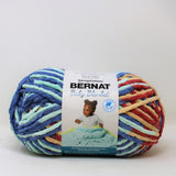 A ball of Bernat Baby Blanket yarn in shade Button Roses (mint, blue, pale yellow, red shades)
