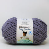 A ball of Bernat Baby Blanket yarn in shade Mountain Mist (dark purpley grey)
