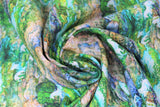 Swirled swatch creek fabric (small repeated creek scene allover - green trees, green moss surrounding flowing blue river, brown and grey rocks, tiny light blue unicorn/horse silhouettes throughout)