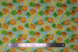 Flat swatch Pinapple Toss fabric (pale blue fabric with tossed full and sliced pineapples allover)