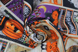 Swirled swatch Patchwork fabric (cream coloured fabric with square and rectangle halloween themed patches with text and graphics: "Happy Halloween" "Spooky Night" etc. and black cats, orange jack-o-lanterns, yellow moons, etc.)