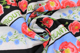 Swirled swatch poppie meadows fabric (medium thick black stripes with red poppies and greenery, thin white stripe with "Sprout" "Grow" etc. text in green, thick sky stripe with poppies and blue floral and hummingbirds, floral stripes)
