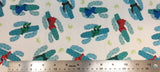 Flat swatch cartoon cactus with scarves printed fabric in white (white fabric with tossed blue medium sized cacti wearing blue, green, red scarves and tossed green grass patch small)