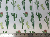 Flat swatch multi cactus style printed fabric in green (white fabric with assorted size/shape cartoon cacti in green shades)
