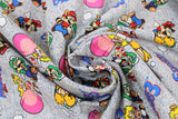 Swirled swatch Go Mario & Friends fabric (grey distressed look fabric with tossed full colour characters in speedy positions Peach, Toad, Luigi, and Mario with tossed 'Super Mario 3' writing in blue, turtle foes, white running clouds)