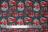 Flat swatch comic swirl fabric (dark grey fabric with assorted rhombus shaped comic panels with black decorative frames and spiderman heads/necks in various poses and sizes)