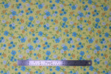 Flat swatch sunshine toss fabric (pale yellow fabric with small tossed wildflower floral in white, blue, orange floral heads with green stems/leaves)