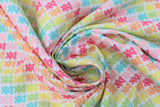 Swirled swatch bright gummy bears fabric (white fabric with gummy bears in rows allover coloured in bright rainbow shades forming diagonal colour stripes)