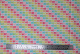 Flat swatch bright gummy bears fabric (white fabric with gummy bears in rows allover coloured in bright rainbow shades forming diagonal colour stripes)
