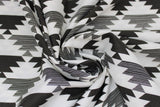 Swirled swatch Mirrored fabric (white fabric with black and grey/white marl upside down triangles with jagged edging alternating in stripes to create geometric pattern allover)