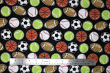 Flat swatch of assorted sports balls fabric on black (black fabric with small tossed soccer, tennis, baseball, football, basketball)