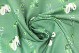 Swirled swatch licensed Harry Potter printed fabric in Slytherin Traits Scatter (crest and text tiled on green)