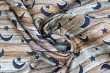 Swirled swatch wood with stars fabric (horizontal grey brown wood planks look fabric with crescent moon and sun cut outs in black)