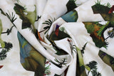 Swirled swatch dinosaur printed fabrics in cream (white fabric with tossed brown rocks allover and dinosaurs in various colours/styles)