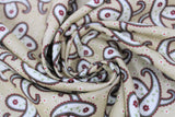 Swirled swatch paisley fabric (beige fabric with tiny tossed white floral heads with pink centers, and large tossed white paisley elements with maroon and green outlines, and maroon long stem flowers within)