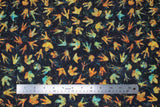 Flat swatch Dino Footprints fabric (black fabric with tossed multi-coloured dinosaur style footprints allover in various sizes/styles)