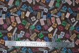 Flat swatch Brown Signs fabric (brown woodgrain look collaged fabric with tossed construction signs allover in various styles/colours "TOOLS" "WORKSHOP" "WET PAINT" etc)