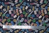 Flat swatch Blue Signs fabric (blue woodgrain look collaged fabric with tossed construction signs allover in various styles/colours "TOOLS" "WORKSHOP" "WET PAINT" etc)