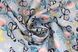 Swirled swatch Butterfly fabric (pale blue grey fabric with tossed butterflies allover in white and black, and white and gold with subtle sparkle detail, tossed white and gold floral and tossed white, pink floral with green stems)