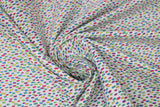 Swirled swatch tropical fabric in colourful specks white (white fabric with tiny blue, yellow, pink, green, purple specks)