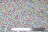 Flat swatch tropical fabric in colourful specks white (white fabric with tiny blue, yellow, pink, green, purple specks)