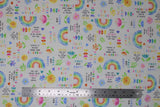 Flat swatch sweet dreams fabric (white fabric with small tossed colourful emblems allover: rainbows, hearts, flowers, "Sweet dreams" text, "Learn and grow" text, etc.)