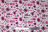 Flat swatch of Marabella fabric in gypsy (white fabric with tossed purple/fuchsia emblems: seeing eyes, hands, birds, moons, plants, etc.)