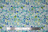 Flat swatch of Marabella fabric in mallorca (white fabric with tiny blue, green, teal emblems collaged together allover: circles, eyes, fish, stars, etc.)