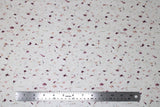 Flat swatch floral printed fabric in Cordovan (white fabric with tiny pink and purple floral colour wisps tossed)