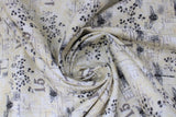 Swirled swatch fabric dragonfly & bee white (white fabric with black and grey bees and dragonflies tossed, "15" text and faded notes looking square shapes with faint writing)