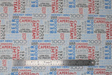 Flat swatch white collage fabric (white fabric with collaged horizontal and vertical text allover in grey, black, red and blues. Canadian themed words and phrases "Canadian Capers" "Hockey Hero" "Cool" etc.)