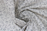 Swirled swatch musical themed printed fabric in music notes (black notes on white)