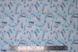 Flat swatch whale themed fabric in Big Splash Light (splash and whale themed text collage on light blue)