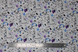 Flat swatch birdy fabric (white with small tossed floral design in grey, blue, and purple with watercolour effect, tossed large blue birds)