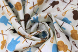 Swirled swatch White Toss fabric (white/cream fabric with tossed music instrument silhouettes in black, blue and gold)
