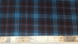 Flat swatch highland tartan printed fabric in blue (dark blue fabric with light blue, red, and black plaid lines)