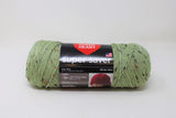 Ball of yarn in frosty green fleck (pale light green yarn with flecks of black, grey, and mustard)