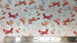 Flat swatch woodland fox and bunny printed fabric in white (white fabric with tossed pink/orange cartoon foxes and bunnies, pink mushrooms, white/pink/green floral and greenery designs)
